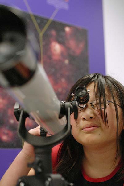 Woman looking through telescope